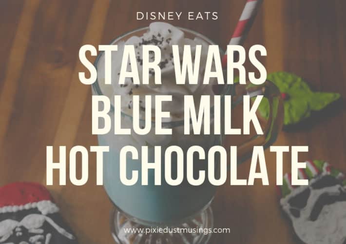 a tall clear glass with blue milk hot chocolate surrounded by Christmas star wars cookies